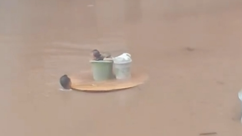 有片-防城港極端暴雨致市區水浸到頸-父親圓桌托起桶裝嬰兒涉水送醫
